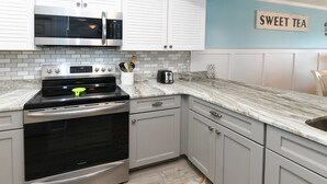 A kitchen with white cabinets, a stainless steel oven, a microwave, and a toaster. - Oceanfront 1 BR Condo with a Shared Pool! South Shores II 201 (Surfside Beach)