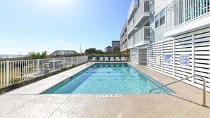 A swimming pool with a 3 ft 3 in depth, surrounded by a white fence, and a sign indicating shallow water and no diving allowed. - Oceanfront 1 BR Condo with a Shared Pool! South Shores II 201 (Surfside Beach)