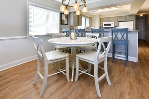 Enjoy meals around the central round table surrounded by six chairs in this well-lit dining area.
