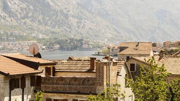 A mountainous landscape with traditional stone buildings and a body of water in the background.