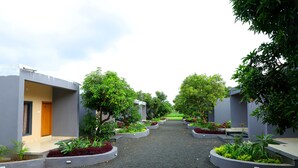 Un sendero bordeado por edificios modernos con terrazas al aire libre y vegetación.