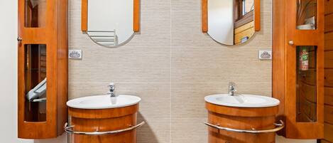 A bathroom with two wooden vanity sinks, each with a mirror above.
