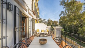 An outdoor patio with a white table, black chairs, and a wooden bowl centerpiece. - Stunning three bedroom town house walking distance to Puente Romano Hotel (Marbella)
