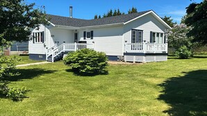 A single-story house with a front porch, a chimney, and a well-maintained lawn. - Quiet Country style living, your home away from home.  (Stephenville)