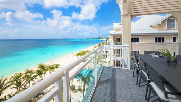 A balcony with a view of a beach and ocean. - Beachcomber 41 by Grand Cayman Villas (7 Mile Beach)