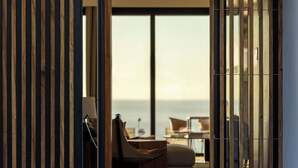Ein modernes Interieur mit einer Holzwand, einem Sofa, einem Sessel und einem Tisch.