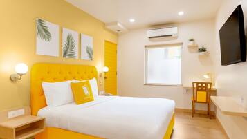 Una habitación luminosa de color amarillo con una cama, un escritorio y una silla.