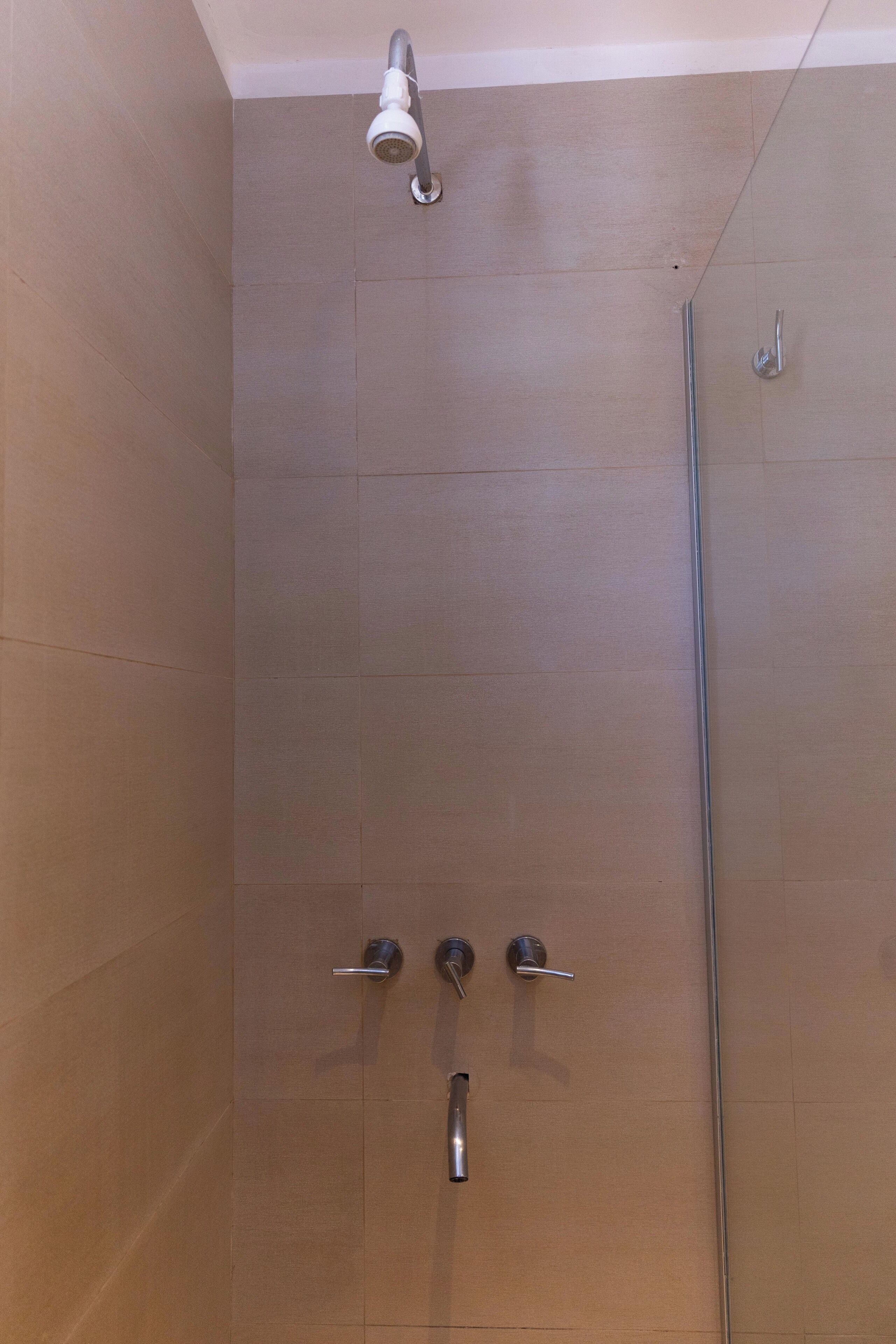 A shower with a glass door and a handheld showerhead.