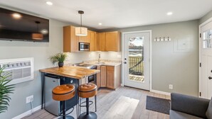 Una cocina moderna con armarios de madera, una isla central y taburetes de bar.