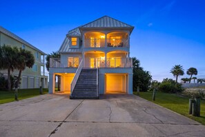 A two-story house with a central staircase, multiple balconies, and a garage.