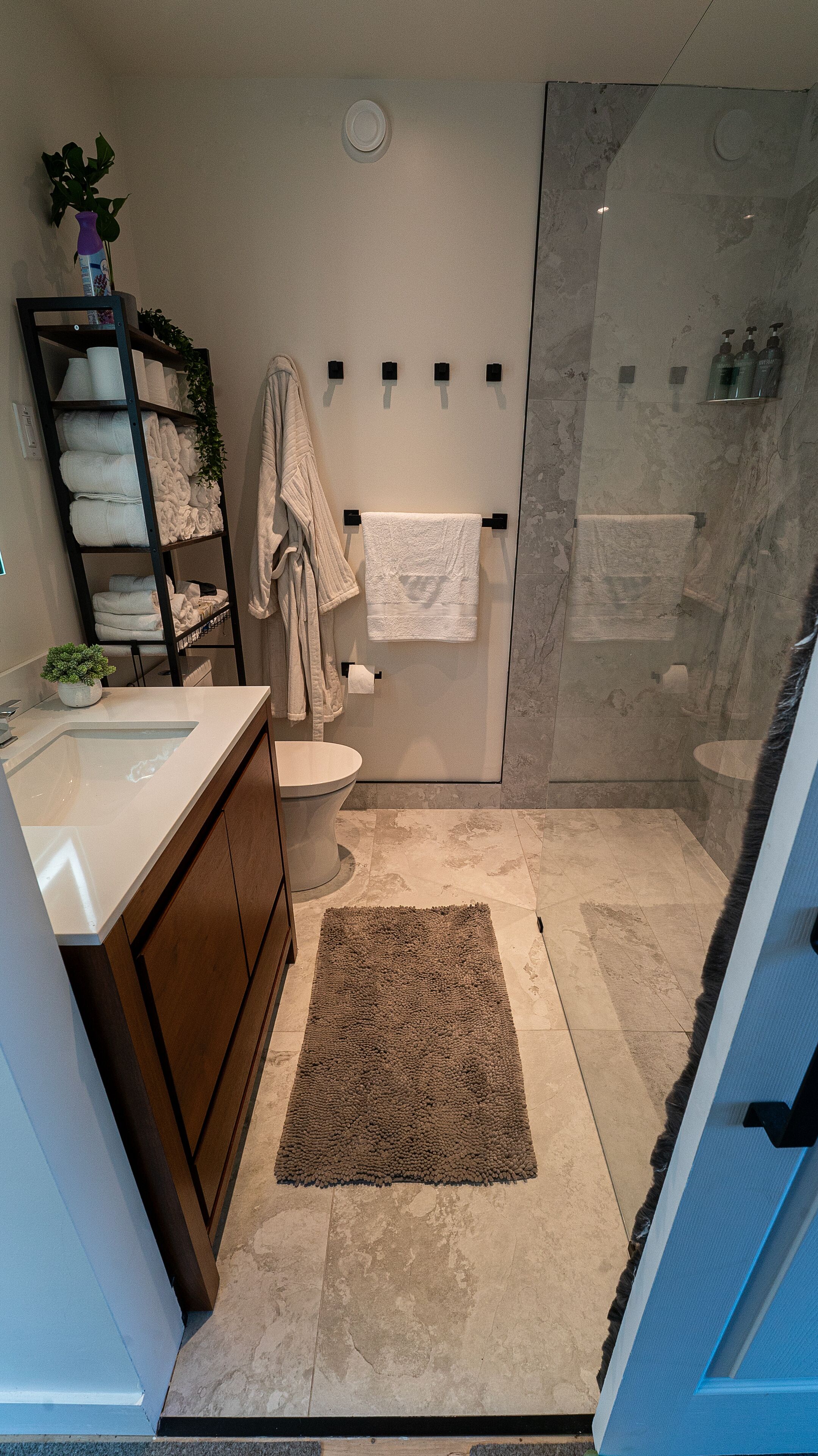 A modern bathroom with a shower, toilet, and sink.