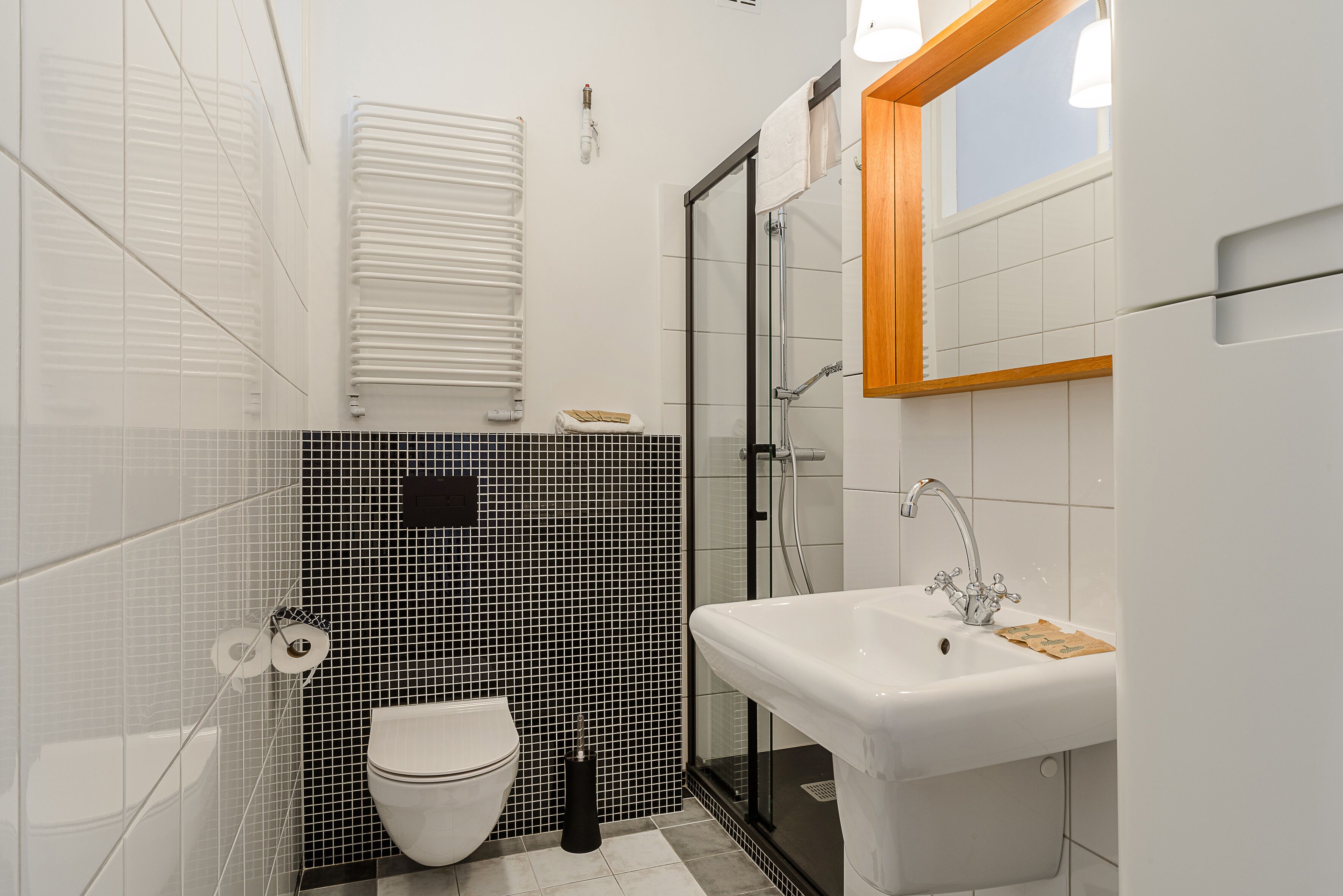 A modern bathroom with a toilet, sink, and glass shower enclosure.
