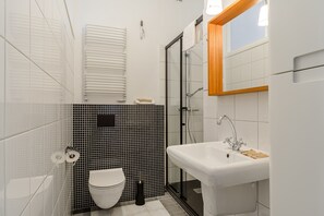 Ein modernes Badezimmer mit Toilette, Waschbecken und Duschkabine.