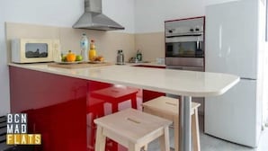A modern kitchen with a central island, a microwave, a stove, and a refrigerator. - Barcelona - Poble Nou (Barcelona)