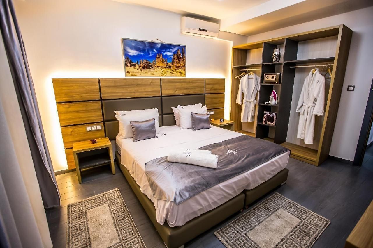 Una habitación de hotel moderna con una cama grande, un armario y un cuadro en la pared.