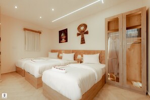 A hotel room with two beds, a wardrobe, a mirror, and a wall with Egyptian-themed decorations. - Queen Ash Pyramids View INN (Giza)