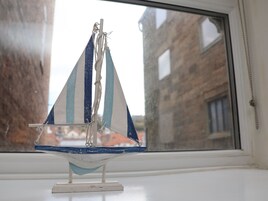 Un velero en miniatura sobre un alféizar.