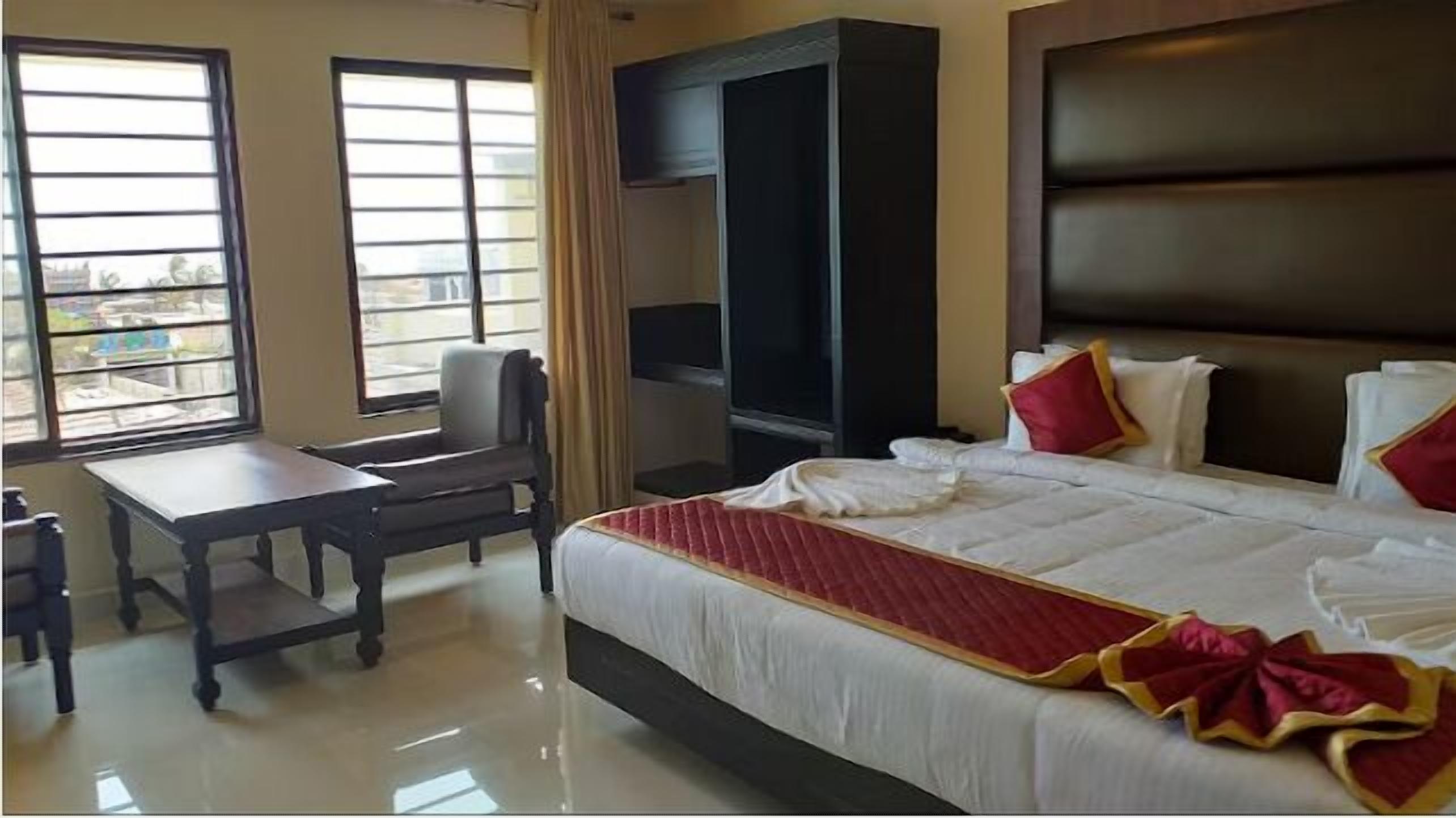 A hotel room with a bed, a desk, and a chair.