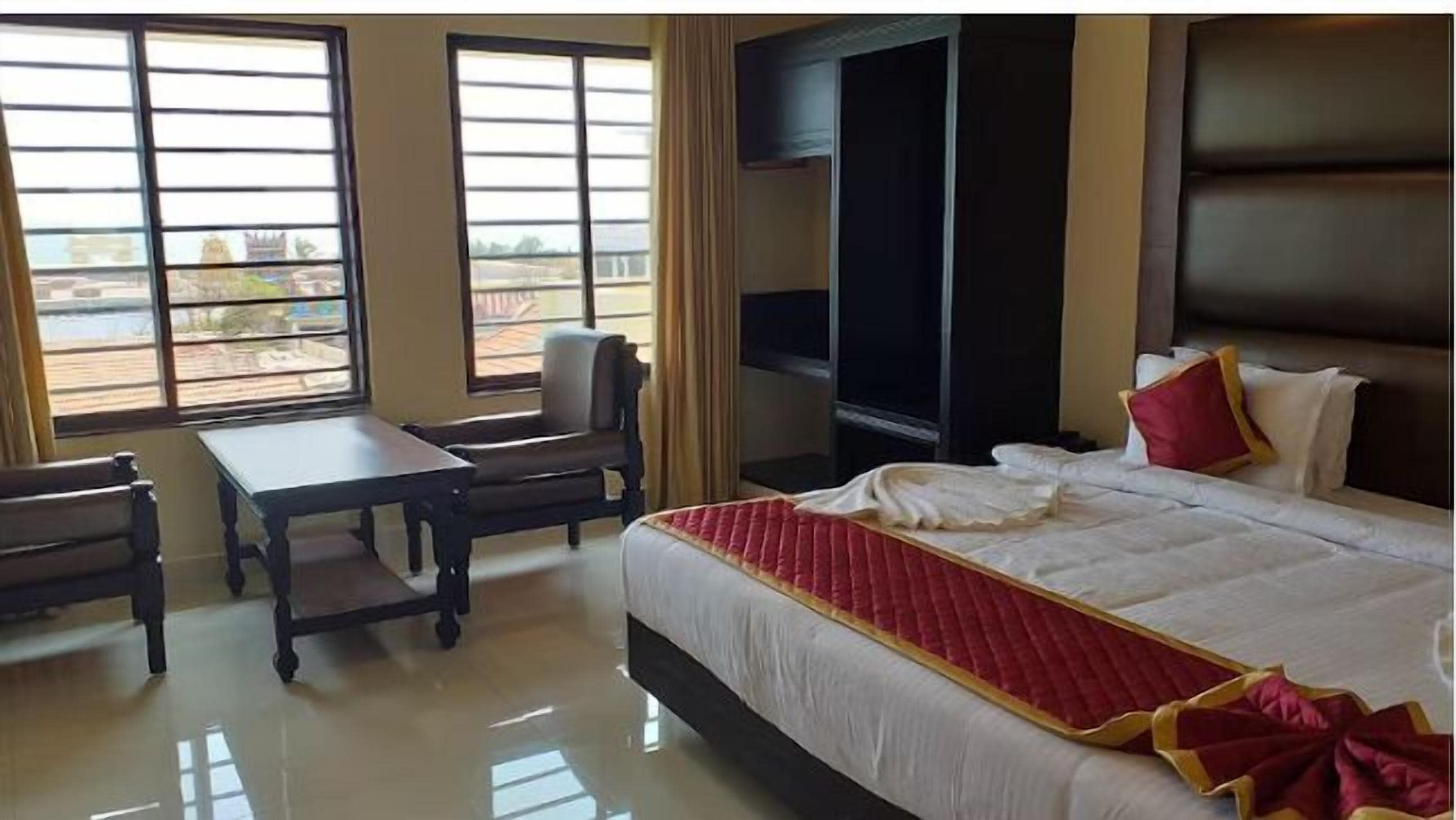 A hotel room with a bed, a desk, a chair, and a TV.