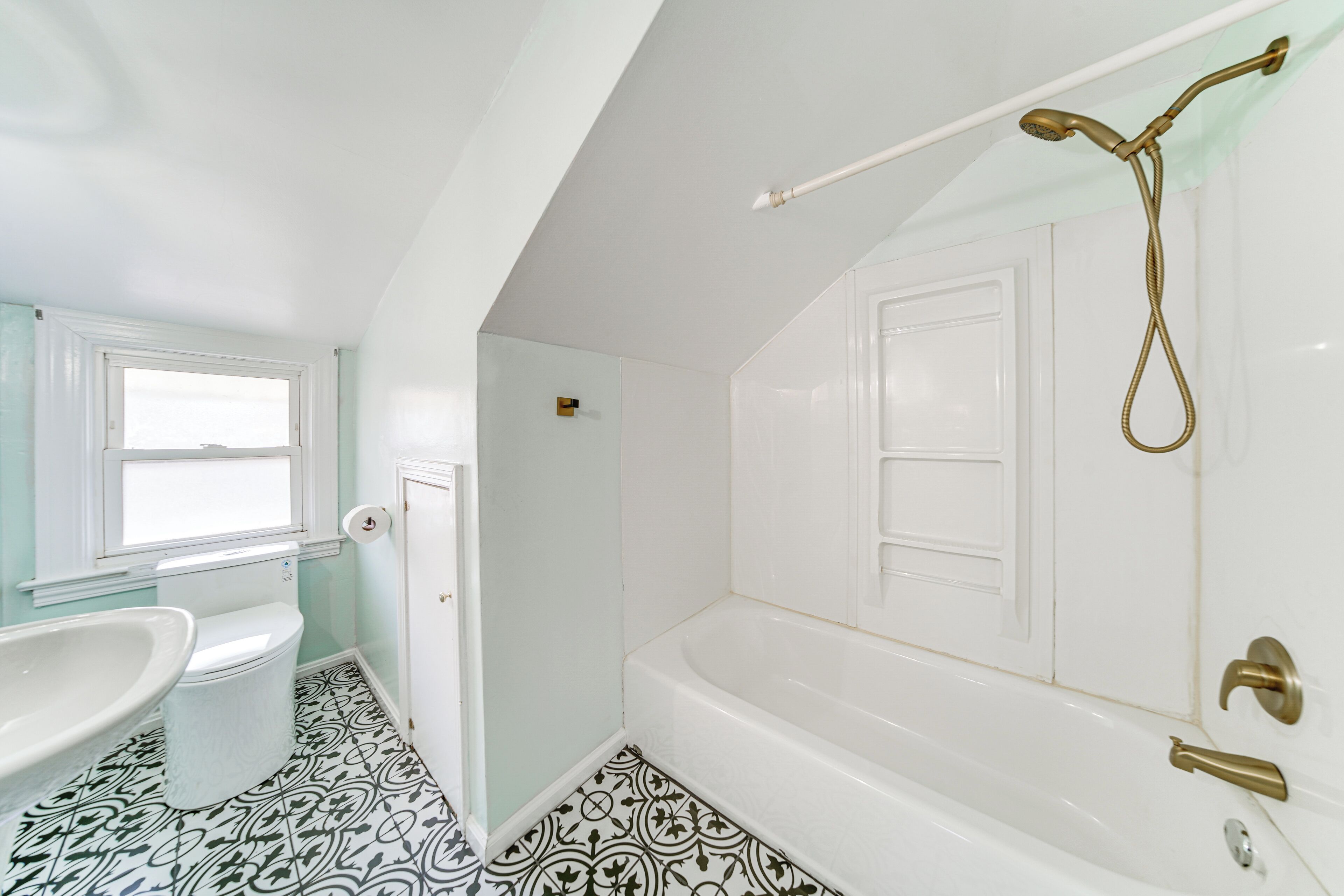 Een badkamer met een wit bad, een wit wastafel en een toilet.