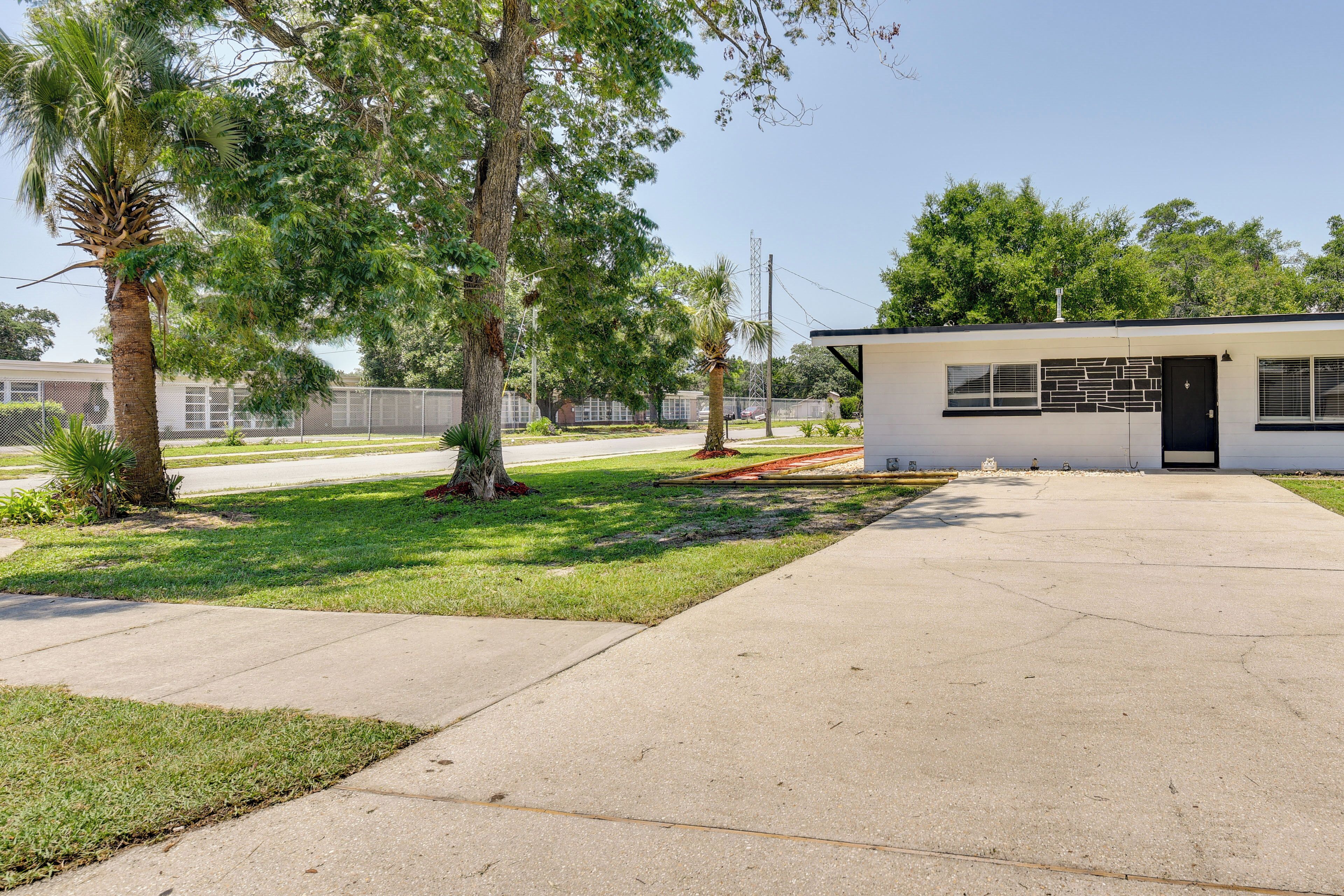 A modern building with a flat roof, a small front porch, and a paved driveway.