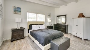A bedroom with a bed, bedside tables, a dresser, a bench, and a wardrobe. - Cozy Fort Walton Beach Escape w/ Private Patio! (Fort Walton Beach)