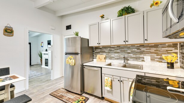 A modern kitchen with white cabinets, stainless steel appliances, and a tiled backsplash. - Cozy Fort Walton Beach Escape w/ Private Patio! (Fort Walton Beach)