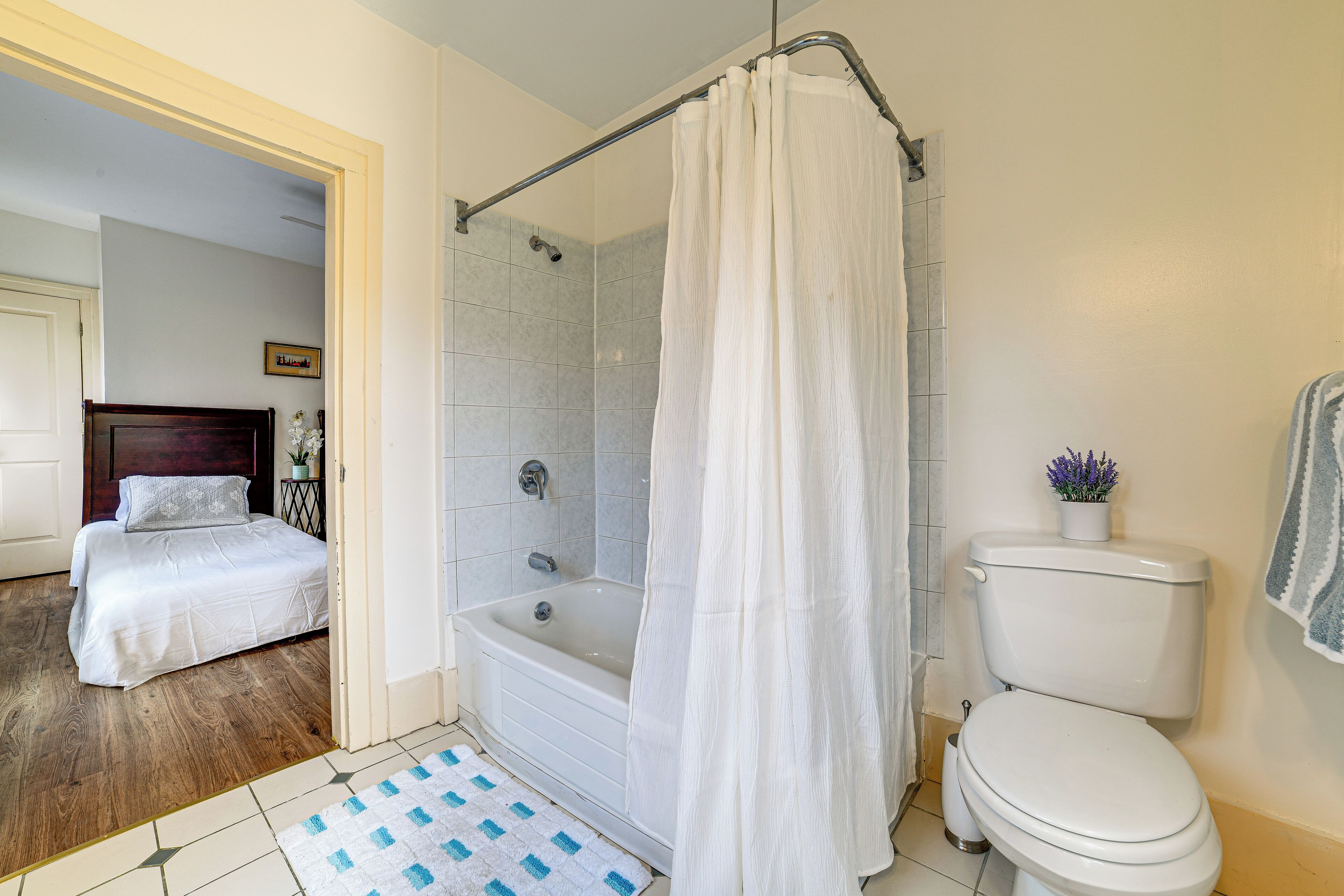 A bathroom with a bathtub, toilet, and shower curtain.