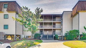 A multi-story building with a central staircase, a covered outdoor area, and a parking lot. - Atlantic Beach Condo w/ Balcony & Beach Access! (Atlantic Beach)