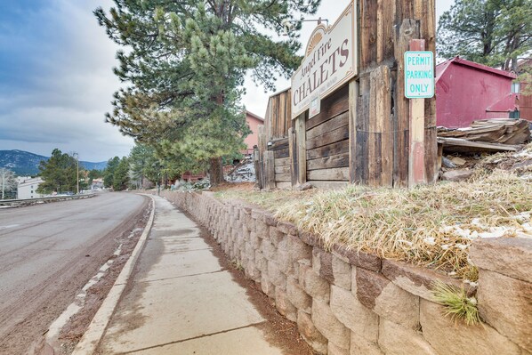 A street with a wooden sign for 'Angel Fire Chalets' and a 'Permit Parking Only' sign.