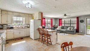 Una cocina amplia con comedor, un refrigerador y una mesa de comedor con sillas.