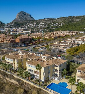 Experience the serene beauty of a mountainous backdrop in this picturesque neighborhood, surrounded by a variety of homes and a well-maintained pool area.