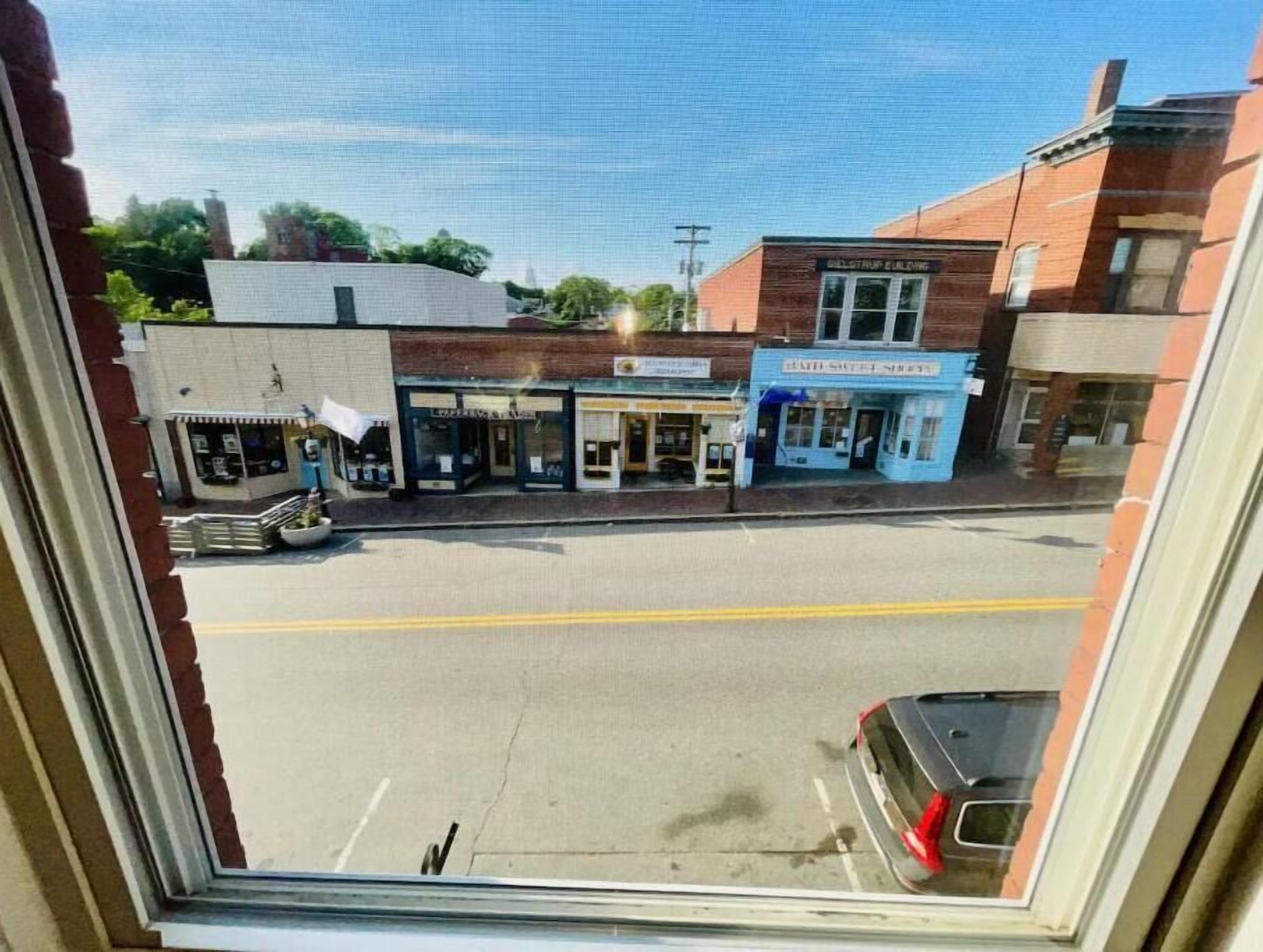 A street view with a row of buildings, including a blue storefront with a sign that reads "Café Street."