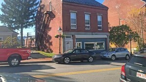 A two-story building with a brick facade, a visible storefront, and a fire escape on the left side. - Modern style in historic building in downtown Bath (Bath)