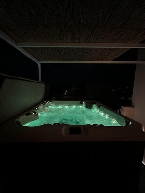 A hot tub under a thatched roof, surrounded by a dark night sky. - Ta' Pinu Spa Suite - Luxury Heritage Living (Zebbug)