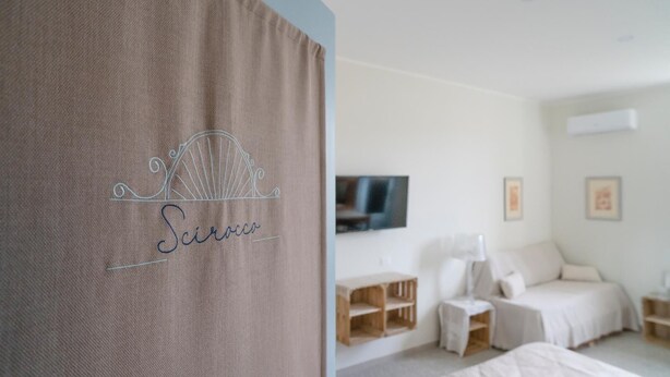 Une chambre à coucher avec un lit, une télévision et une étagère en bois.