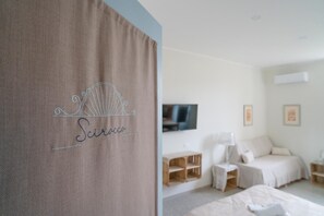 Une chambre à coucher avec un lit, une télévision et une étagère en bois.