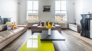 Uma sala de estar moderna com dois sofás, uma mesa de centro e uma lareira.