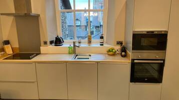 Et moderne køkken med vindue, rustfrie stålapparater og byudsigt.
