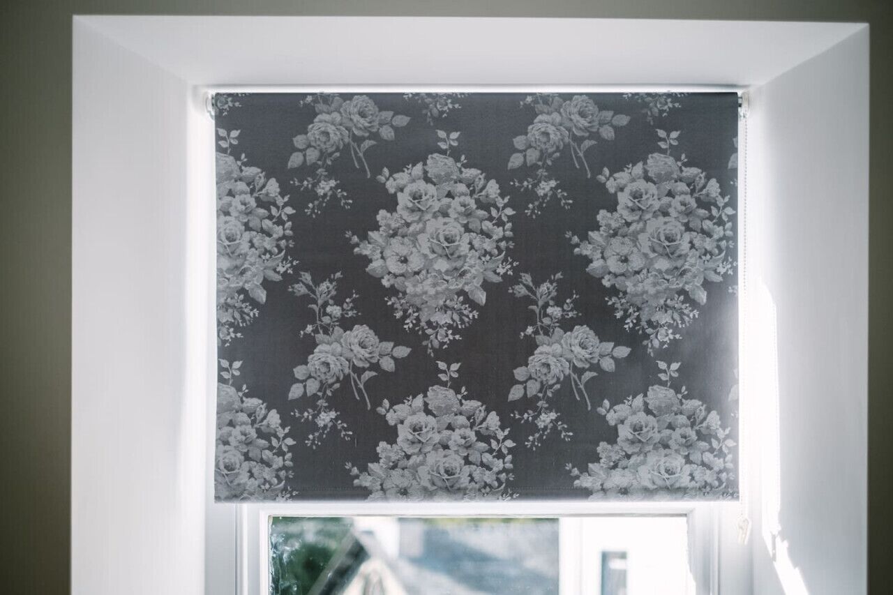 A window with a floral-patterned blind.