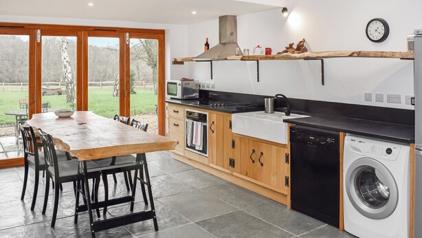 A modern kitchen with a dining area, large windows, and a view of the outdoors. - UK46591 - Polecat Barn (Plumpton Green, near Lewes)