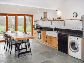 A modern kitchen with a dining area, large windows, and a view of the outdoors. - UK46591 - Polecat Barn (Plumpton Green, near Lewes)