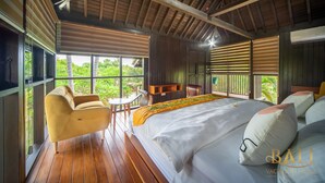 Un dormitorio amplio con una cama grande, un sofá y una mesita.