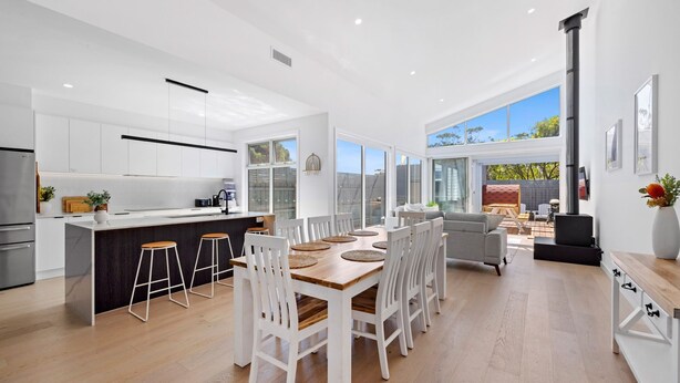 A modern kitchen with white cabinetry, a central island, and bar stools. - The Sanctuary - Rosebud (Rosebud)