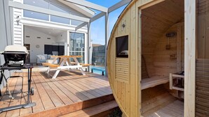 A wooden cabin with a deck, a barbecue grill, and a pool area. - The Sanctuary - Rosebud (Rosebud)