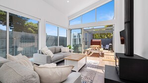 A modern living room with a grey sofa, a coffee table, and a TV on a stand. - The Sanctuary - Rosebud (Rosebud)
