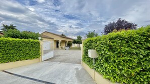 A gated entrance to a building with a gravel driveway, surrounded by well-maintained hedges and a clear sky. - Villa 6p, 3ch Avec Grand Jardin Arboré Clos, Clim, Village Classé de Vogue (Vogüé)