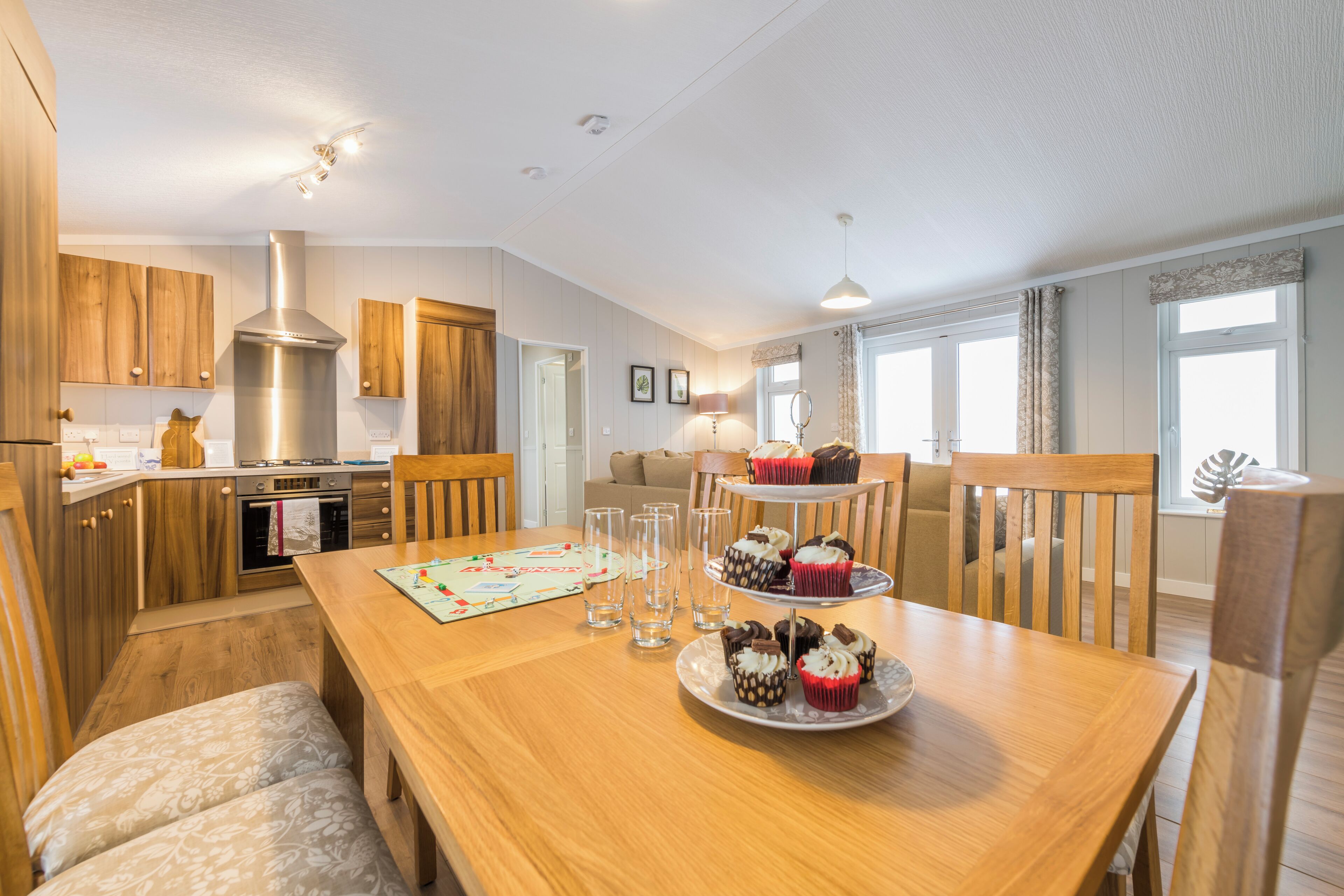 A spacious kitchen with wooden cabinets, a stainless steel range hood, and a dining area with a wooden table and chairs.