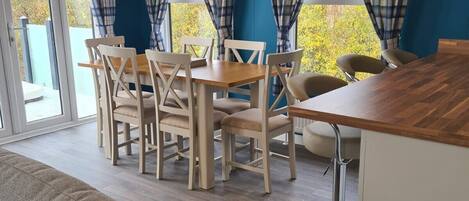 En matplats med ett träbord och stolar, en soffa och en papperskorg.