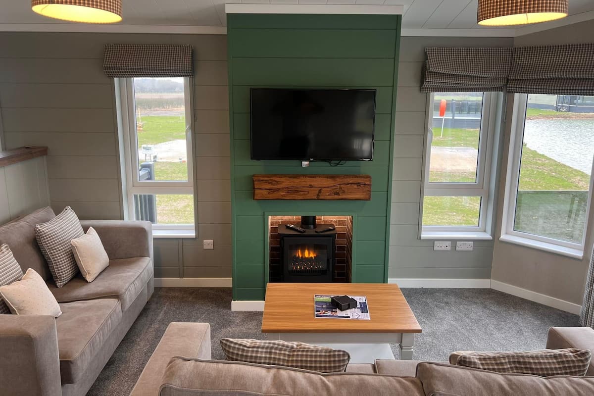 A cozy living room with a fireplace, a flat-screen TV, and a comfortable seating area.